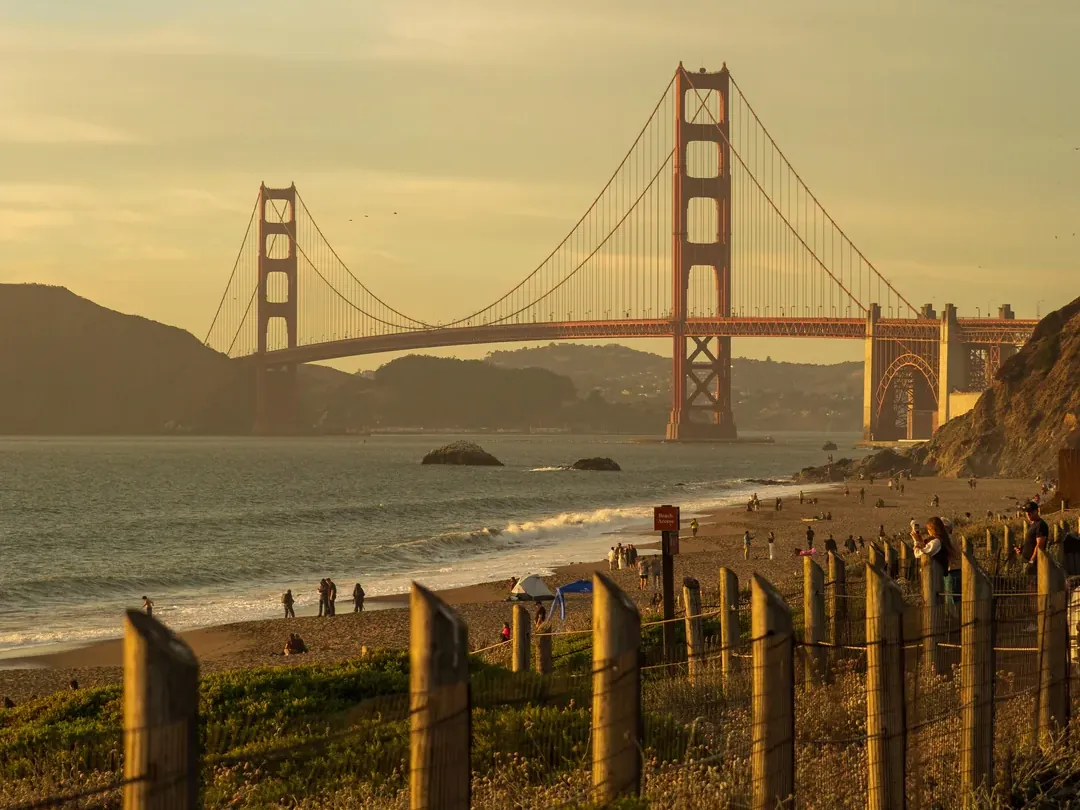 Baker Beach at sunset with the Golden Gate Bridge and dune fencing